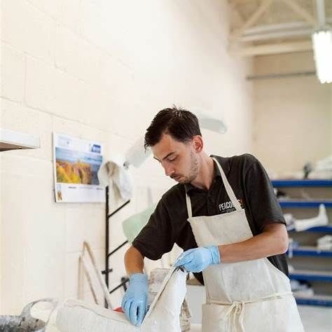 Ein Mann in einer Schürze arbeitet an einem Gips